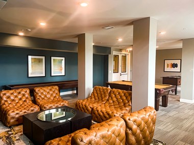 The community clubhouse with couch and table at The Lofts at Canterbury in Slidell, Louisiana