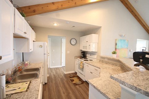 a kitchen with white cabinets and granite counter tops