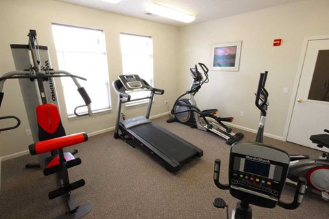 Fitness center with cardio equipment and a weight machine at Canterbury Apartments in Kalamazoo, Mi