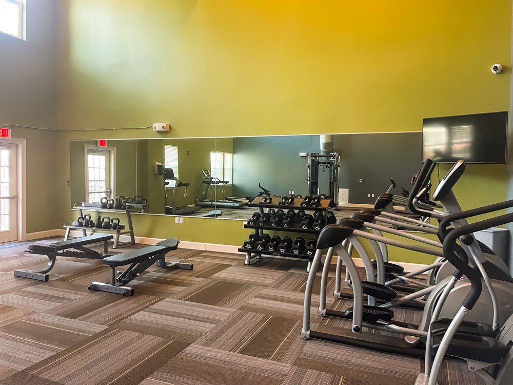Fitness center with weights, weight bench, and ellipticals at The Lofts at Canterbury in Slidell, Louisiana