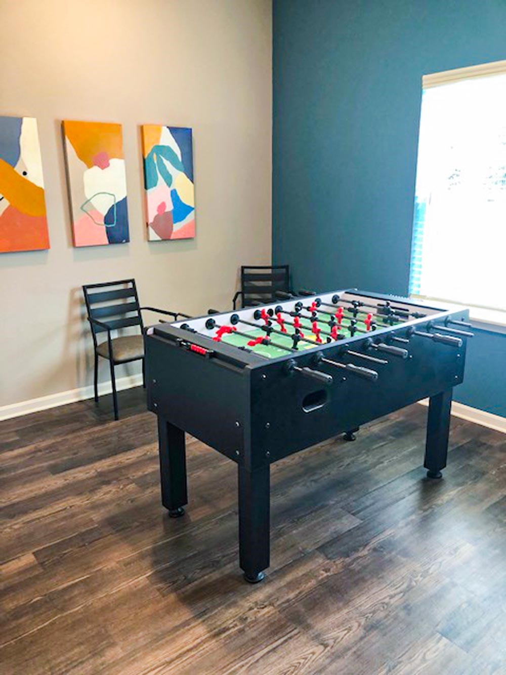 A foosball table in a small room with pictures on the wall