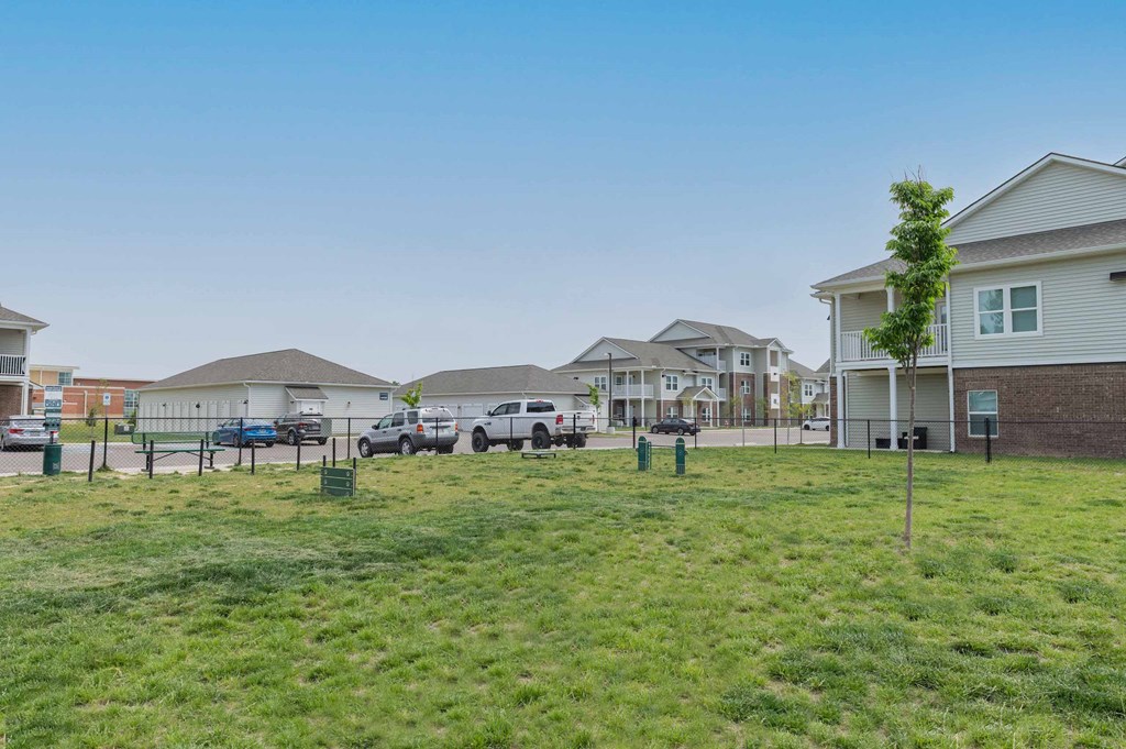 A fenced in dog park with a tree at Crossing at Grove City apartments in Grove City, OH