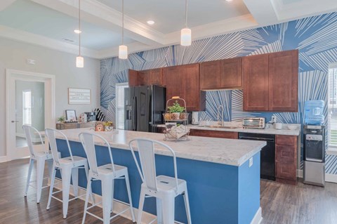 a kitchen with a blue island and white chairs