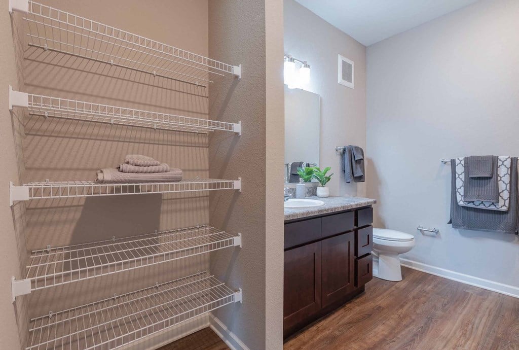 Bathroom with a sink and a toilet and shelves at grove city apartments