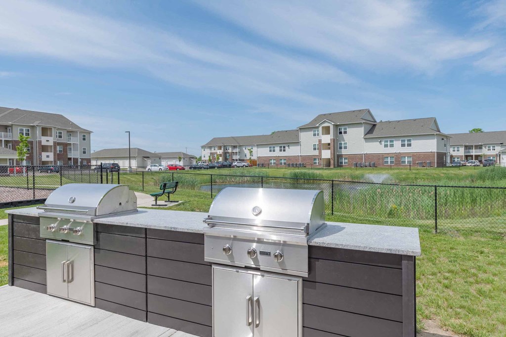 Community grill and bbq with a view of the apartments in the background