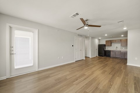 A room with a ceiling fan and wooden flooring.