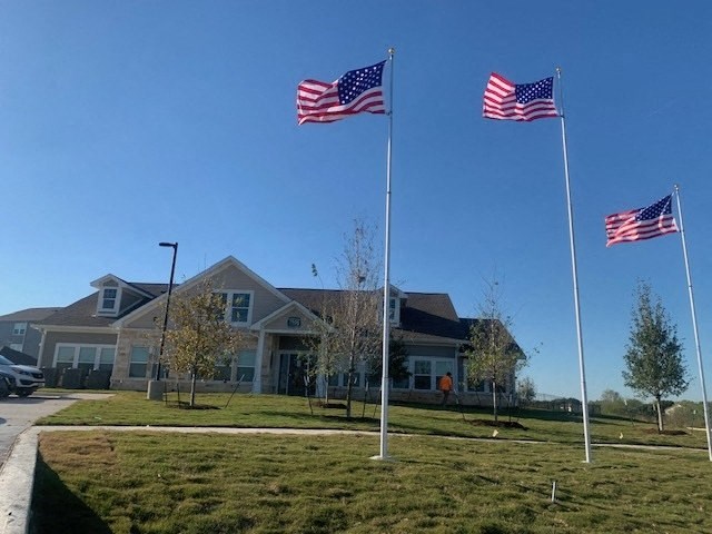 four flags flying in front of Agave East leasing office