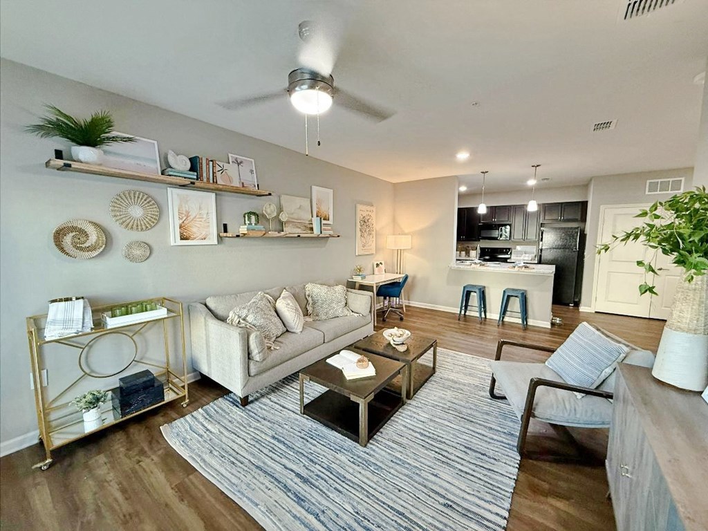 A living room with a white couch, a coffee table, and a ceiling fan.