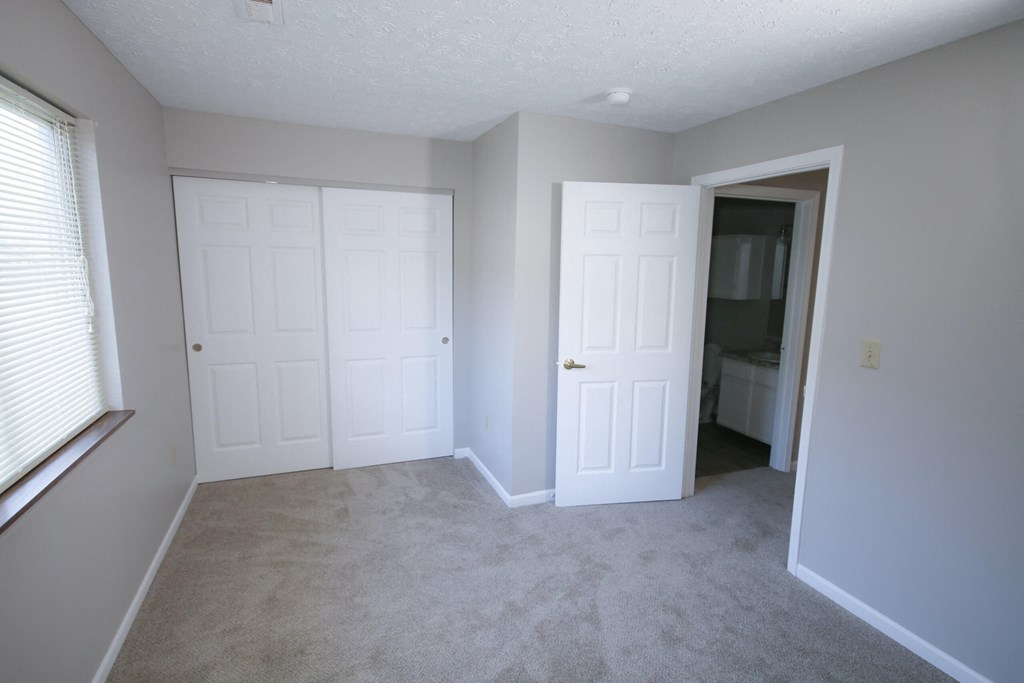 an empty bedroom with two doors and a closet at Frankfort Place apartments in Frankfort, Indiana