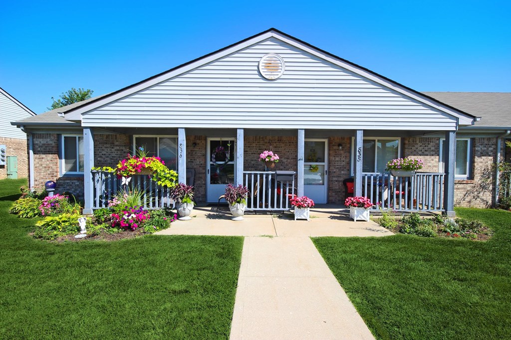 the front of Frankfort Place apartments clubhouse with flowers on the porch