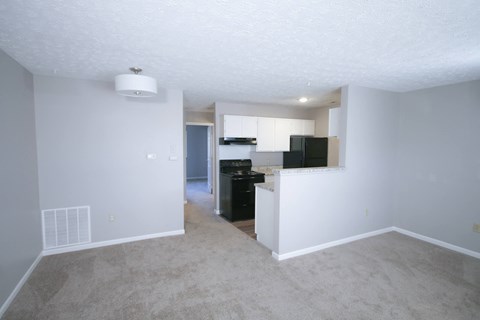 an empty living room with a kitchen in the background at Frankfort Place apartments in Frankfort, Indiana
