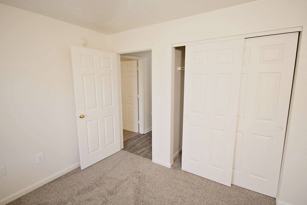 a bedroom with two closets and a door to a hallway