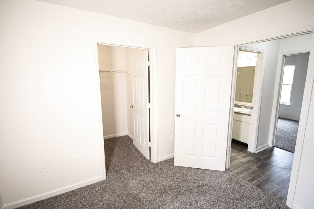 a bedroom with two closets and a door to a bathroom