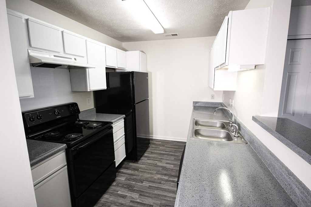 a kitchen with black appliances and white cabinets