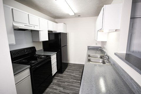 a kitchen with black appliances and white cabinets