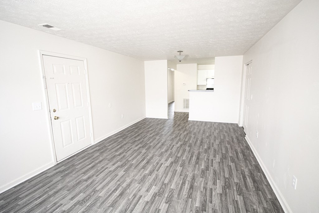 an empty living room with white walls and wood flooring