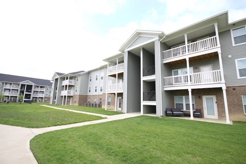Apartment complex with a green lawn in front.