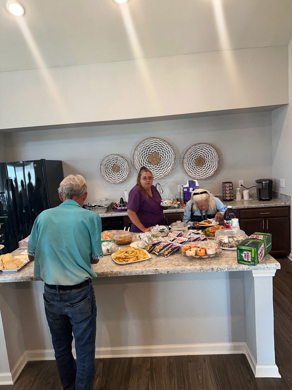 people preparing food at a counter in a kitchen