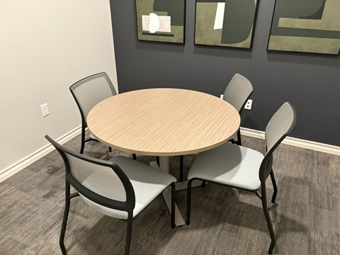 A round table with four chairs around it.