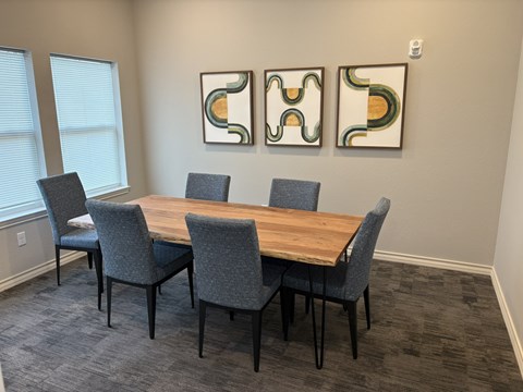 A conference room with a long table and chairs.