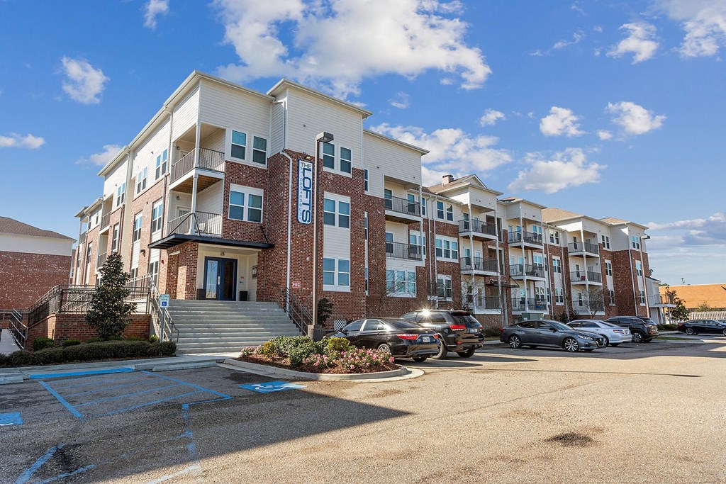 Exterior view of The Lofts apartment building with cars parked in front of it