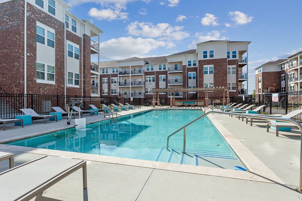 pool with lounge chairs with apartment buildings at The loft apartments in Slidell, LA