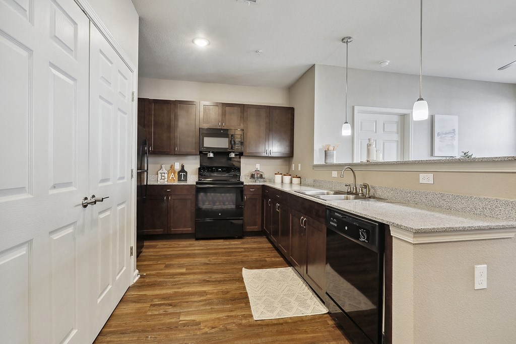 kitchen with a large island and black appliances at The Lofts apartments in Slidell, LA