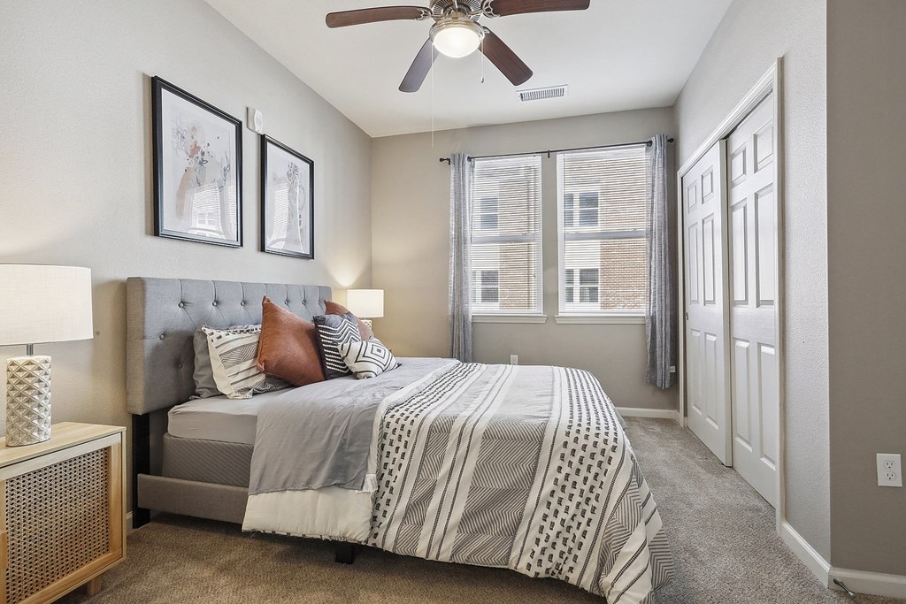 a bedroom with a bed and a ceiling fan