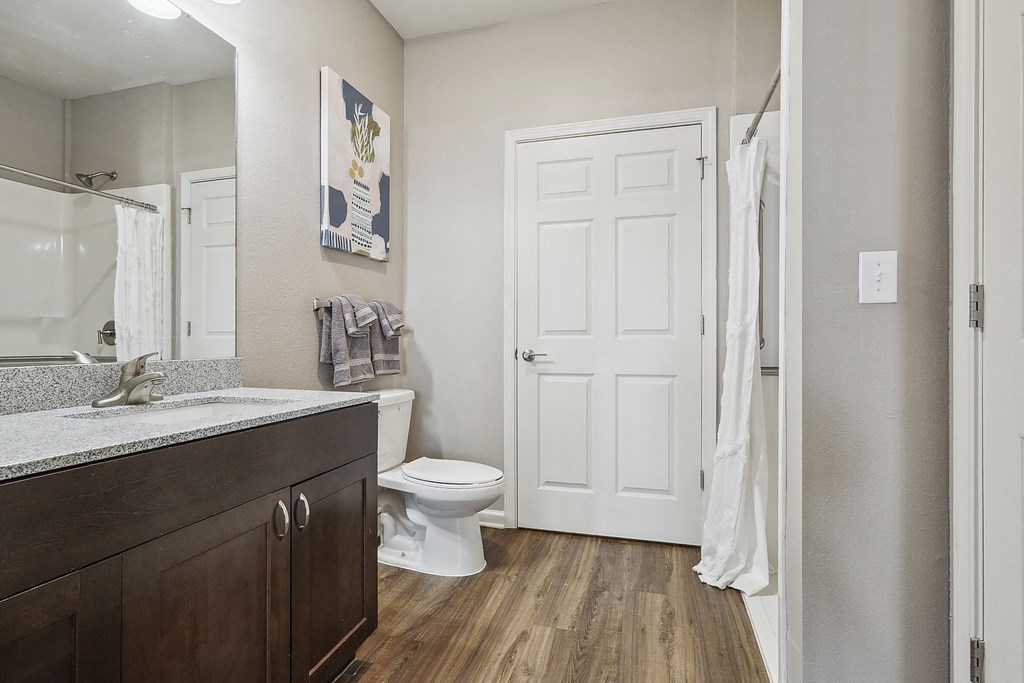 a bathroom with a white door and a toilet and a sink