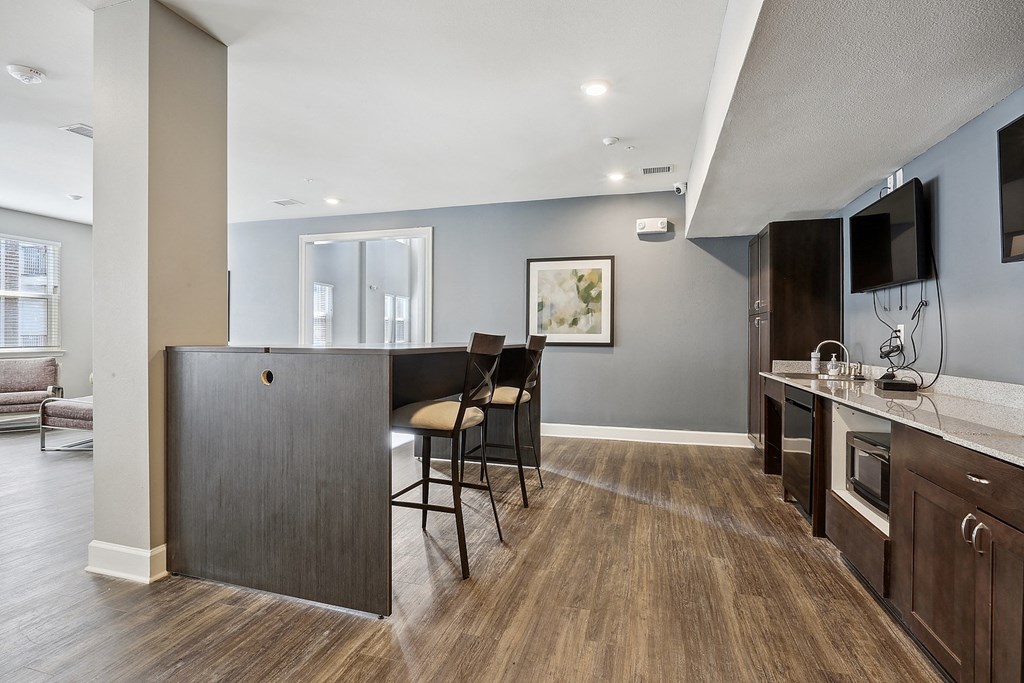 a kitchen and living room with a bar and a table with chairs