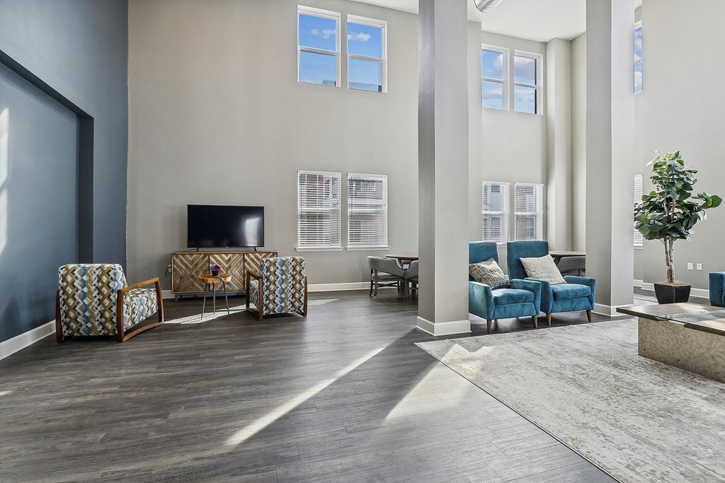 a living room with blue chairs and a tv