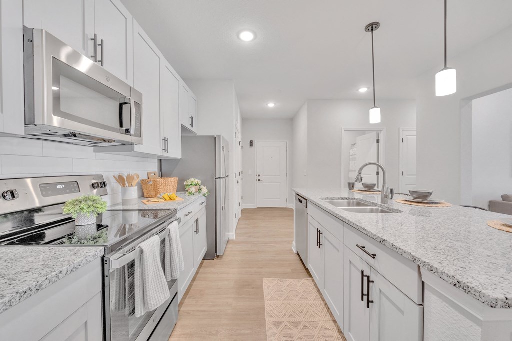 a large kitchen with marble counter tops and white cabinets at spire luxury apartments in charlotte nc