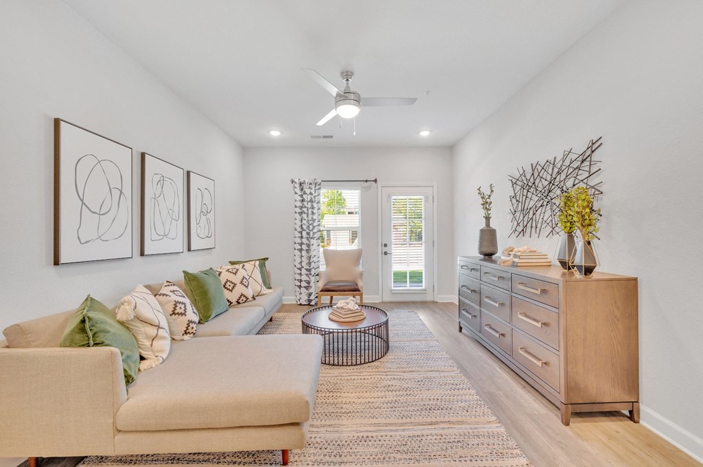 a living room with furniture and a ceiling fan at spire apartments in charlotte nc