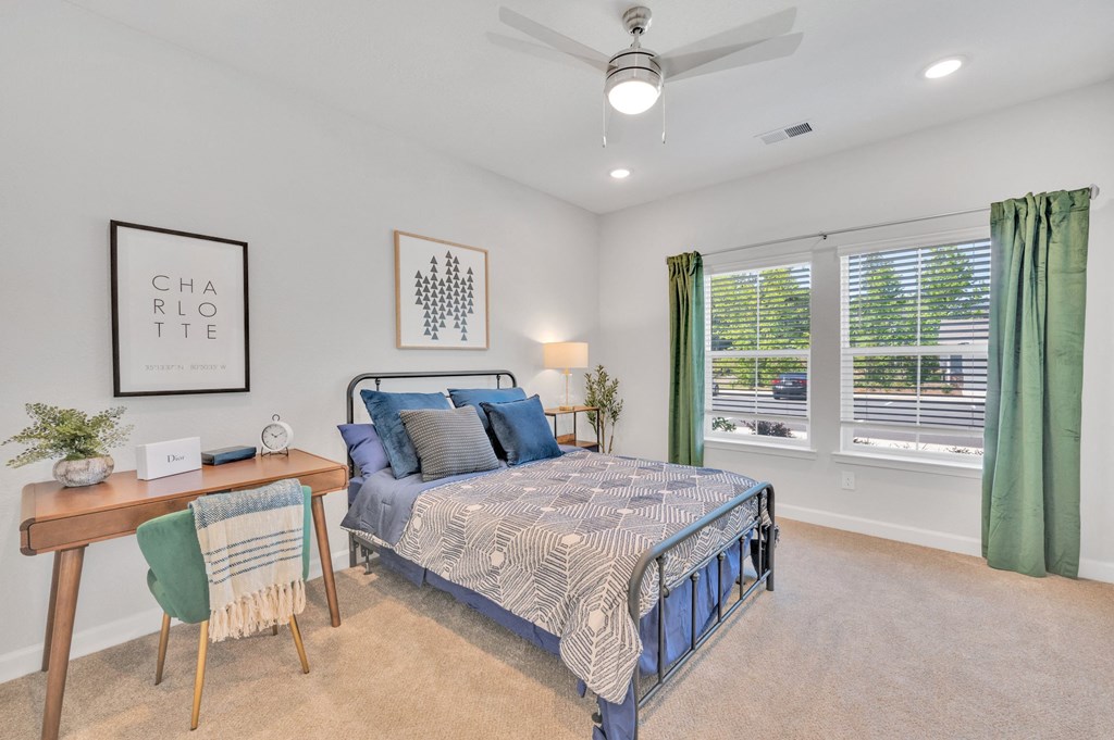 a bedroom with a bed and two windows at spire luxury apartments