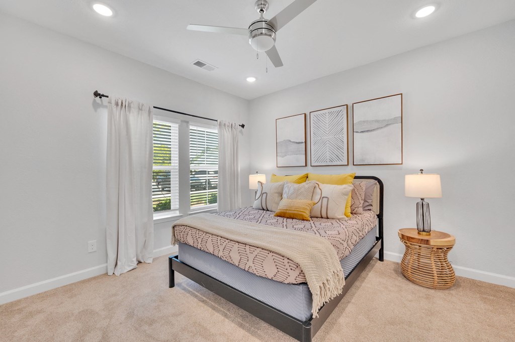 a bedroom with a bed and a ceiling fan at spire luxury apartments