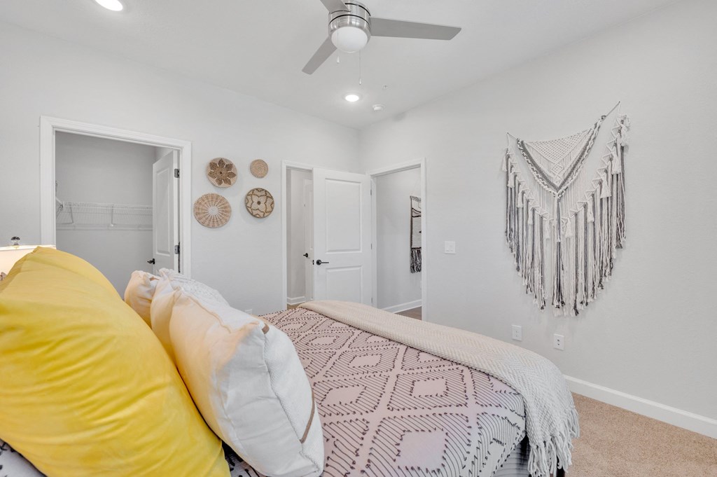 a bedroom with a bed and a ceiling fan at spire luxury apartments
