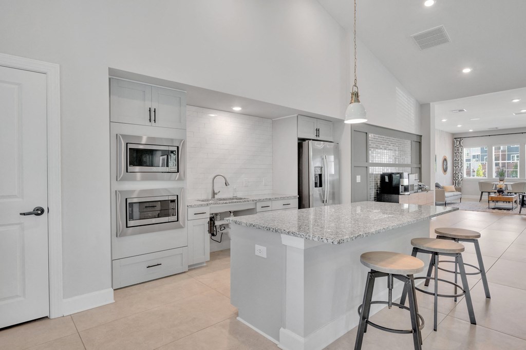 a kitchen with a large island with bar stools at spire apartments