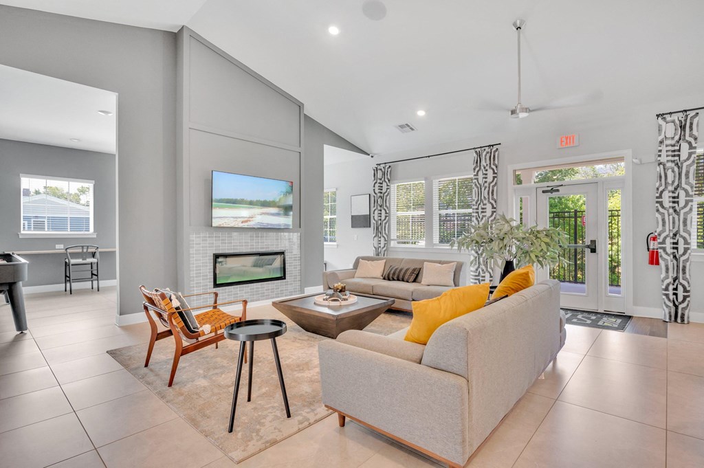 community lounge area with a couch and a chair and a fireplace at spire luxury apartments in charlotte nc