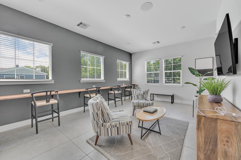community room with chairs and a table and a television at spire apartments