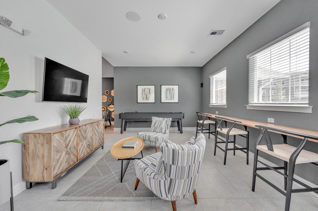 community room with a table and chairs and a television at spire apartments