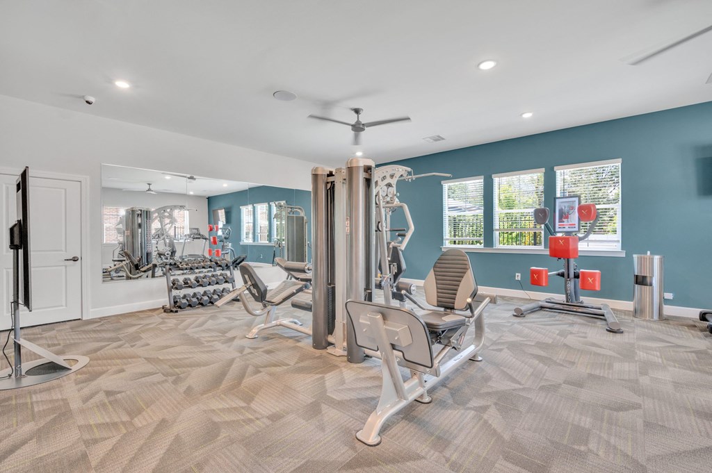 fitness center with cardio equipment and weights at spire apartments