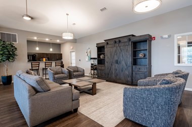 Clubhouse living room with couches chairs and a coffee table at Mosaic Apartments