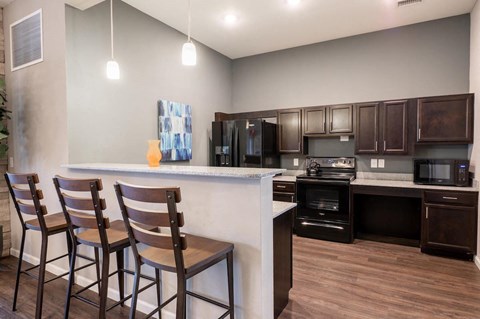 a kitchen with a counter and three chairs