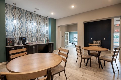 Clubhouse room with a table and chairs and a counter with a coffee maker at Mosaic Apartments in Avon, Indiana
