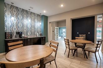 Clubhouse room with a table and chairs and a counter with a coffee maker at Mosaic Apartments in Avon, Indiana