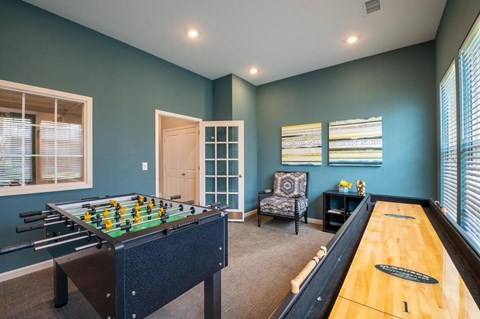 Game room with a foosball table and shuffle board at Mosaic Apartments in Avon, Indiana