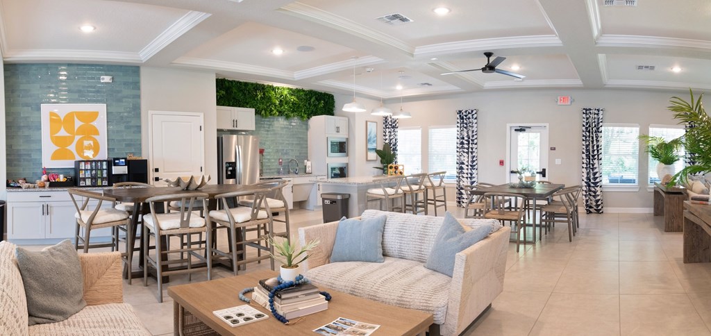 A spacious living room with a kitchen in the background.