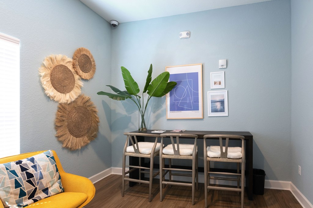 A room with a yellow chair and a table with chairs.