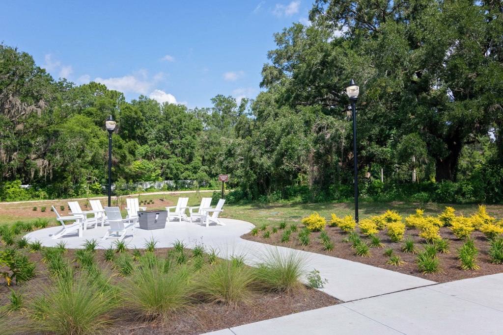 A white table and chairs are set up in a park.