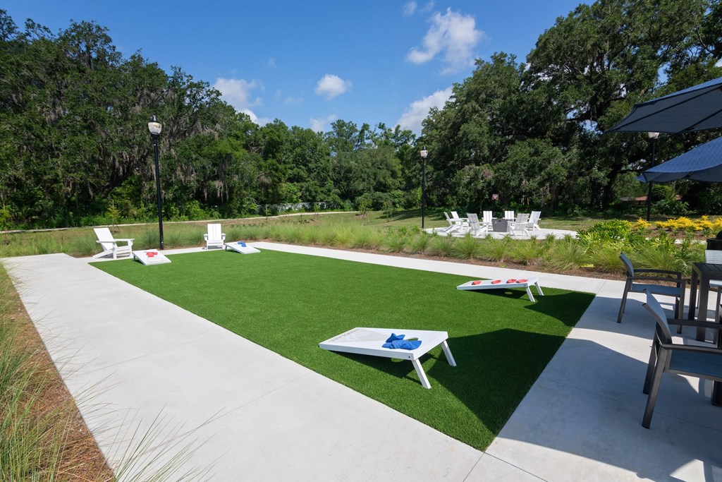 A sunny day at the park with a table and chairs set up on the grass.